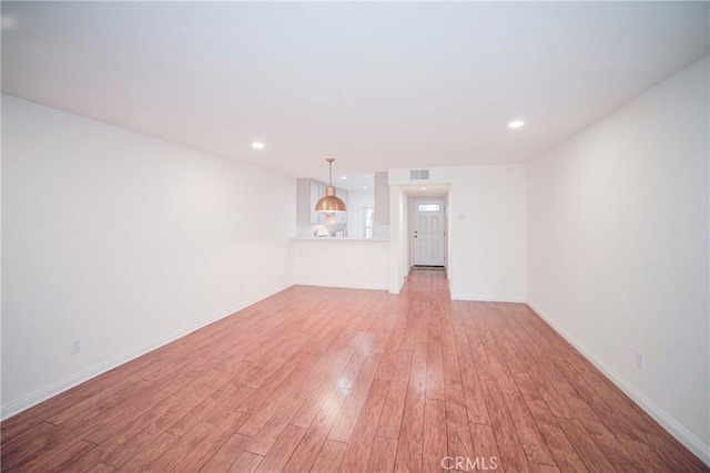 unfurnished living room featuring visible vents, recessed lighting, baseboards, and light wood-style floors