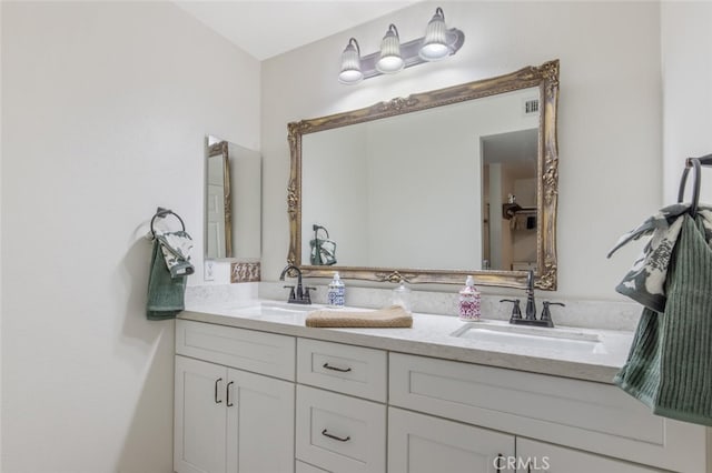 bathroom featuring a sink, visible vents, and double vanity