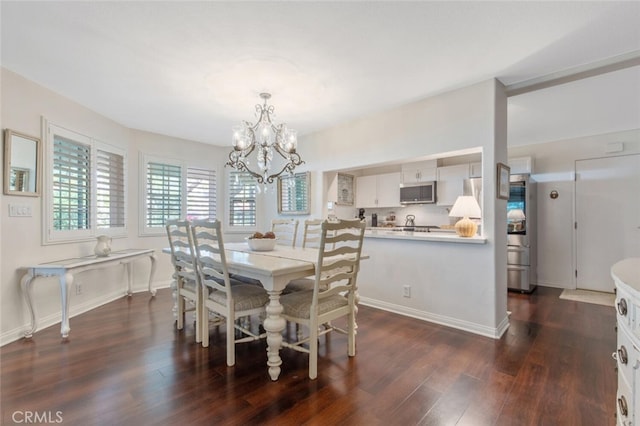 dining room with baseboards, a notable chandelier, and dark wood-style floors