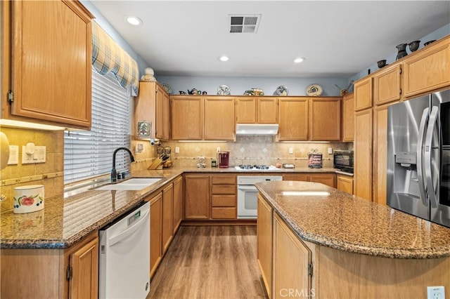 27950 Periwinkle Ln, Valencia, CA 91354 - kitchen featuring white appliances, under cabinet range hood, light wood-type flooring, light stone countertops, and decorative backsplash