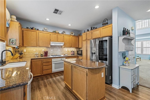 27950 Periwinkle Ln, Valencia, CA 91354 - kitchen with appliances with stainless steel finishes, under cabinet range hood, dark wood-type flooring, dark stone countertops, and recessed lighting