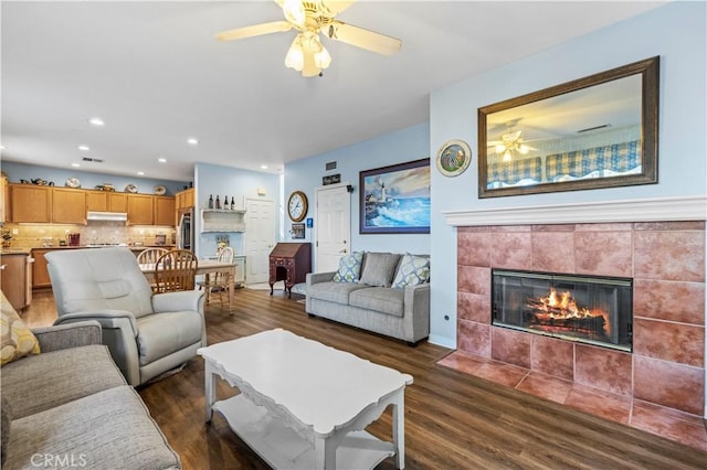 27950 Periwinkle Ln, Valencia, CA 91354 - living room with ceiling fan, dark wood-style floors, a tiled fireplace, and recessed lighting