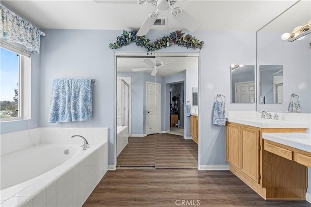 27950 Periwinkle Ln, Valencia, CA 91354 - full bathroom with ceiling fan, vanity, a garden tub, wood finished floors, and a shower stall