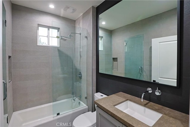 full bath featuring combined bath / shower with glass door, toilet, and vanity