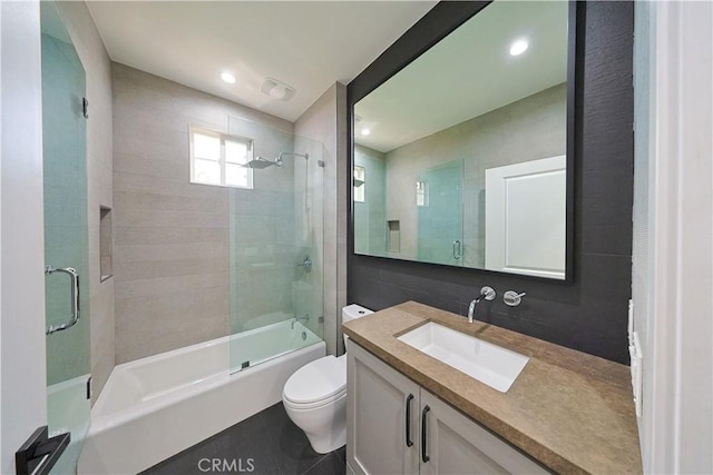 bathroom featuring vanity, toilet, recessed lighting, and shower / bath combination with glass door