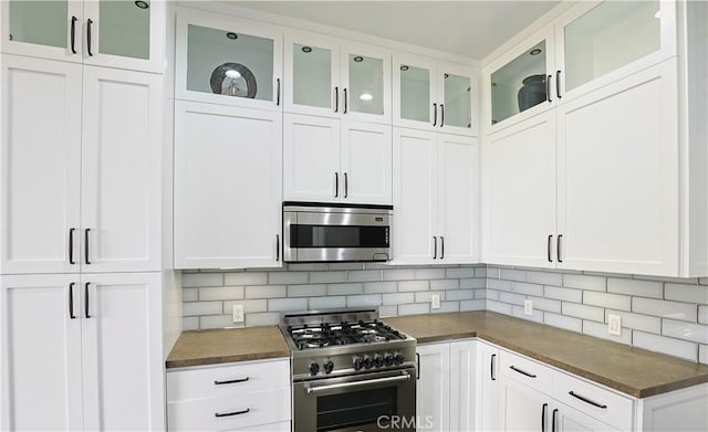 kitchen with dark countertops, appliances with stainless steel finishes, and tasteful backsplash