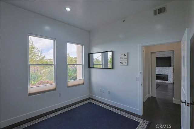 unfurnished room with visible vents, recessed lighting, a fireplace, and baseboards