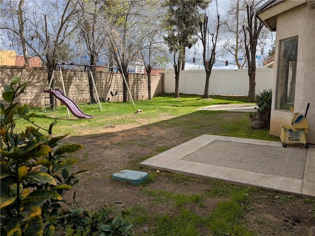 view of yard with a patio, a playground, and a fenced backyard