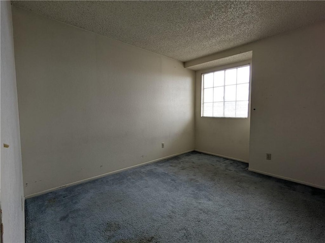 empty room with baseboards, carpet floors, and a textured ceiling