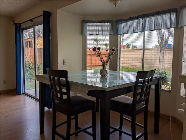 dining area featuring wood finished floors and baseboards