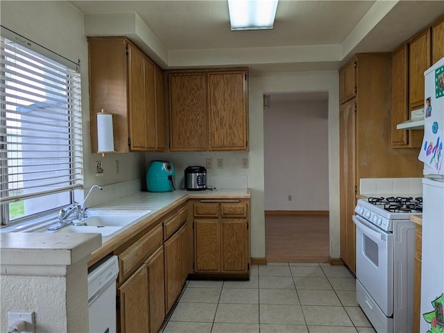 kitchen featuring a wealth of natural light, white appliances, under cabinet range hood, and light countertops