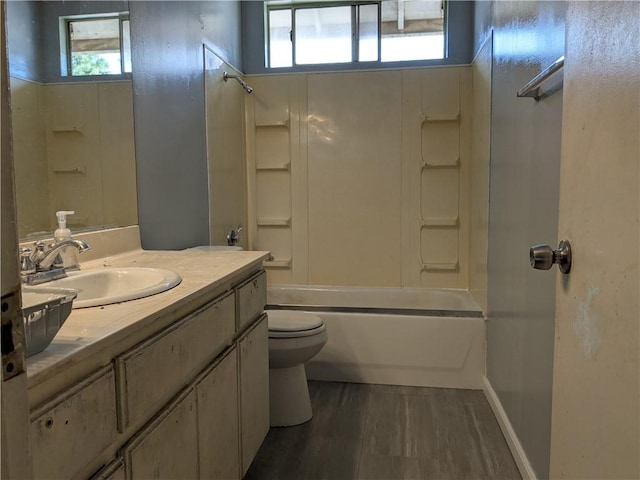 bathroom with tub / shower combination, toilet, vanity, and wood finished floors