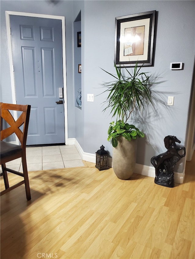 foyer featuring wood finished floors and baseboards