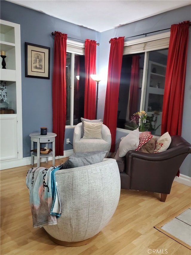 living area featuring baseboards and wood finished floors