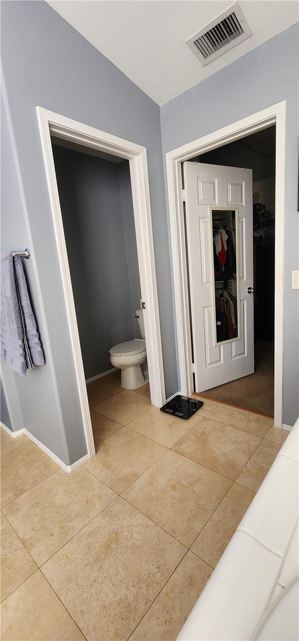 bathroom with visible vents, baseboards, toilet, and tile patterned flooring