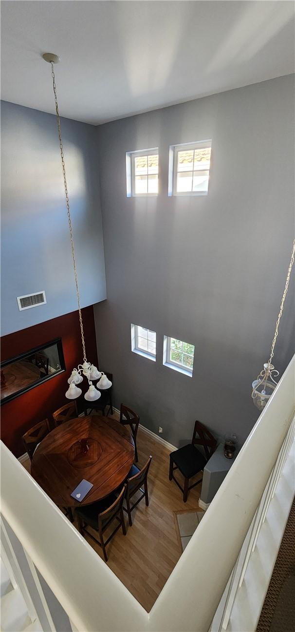 living area featuring visible vents and wood finished floors