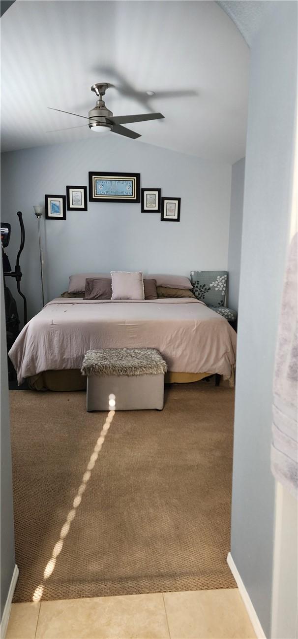 tiled bedroom featuring a ceiling fan