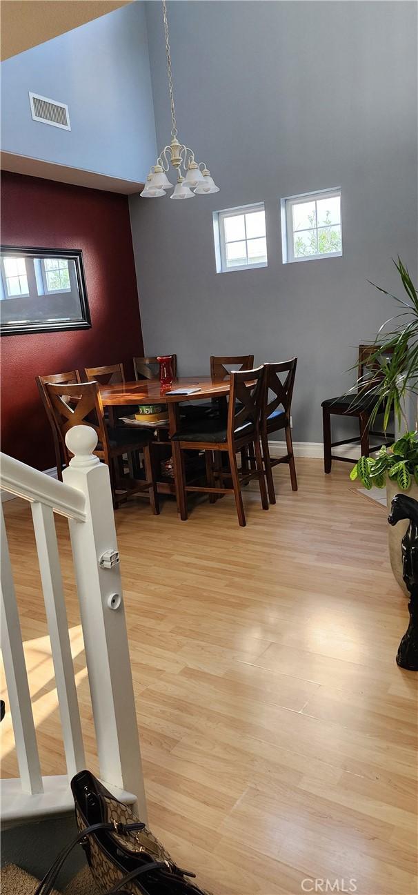 dining room featuring visible vents, wood finished floors, and a chandelier