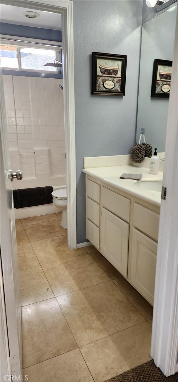 bathroom with tile patterned flooring, shower / tub combination, toilet, and vanity