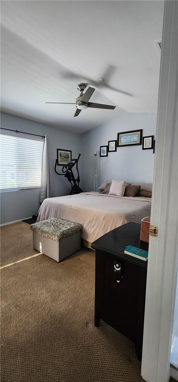 carpeted bedroom with lofted ceiling and ceiling fan