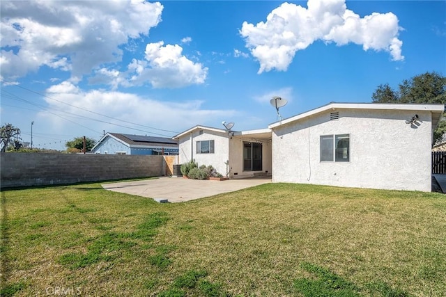 back of property featuring a yard, a patio area, a fenced backyard, and stucco siding