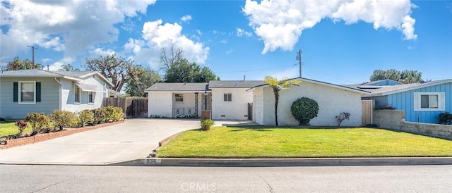 ranch-style home with stucco siding, concrete driveway, a front lawn, and fence