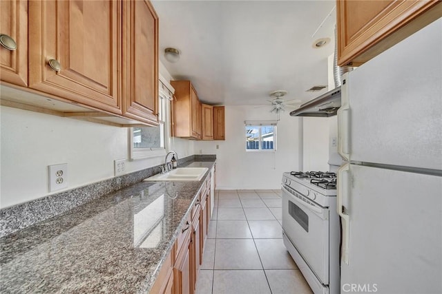 kitchen with white appliances, light tile patterned floors, ceiling fan, a sink, and under cabinet range hood