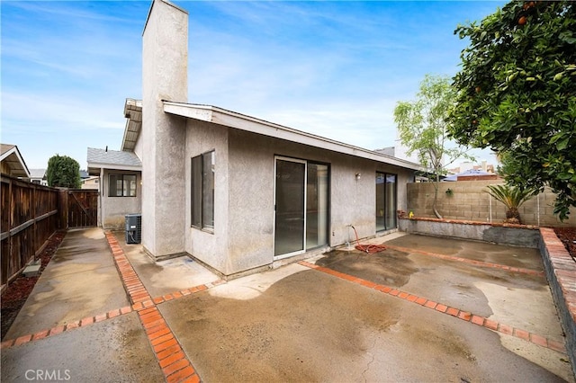 back of house with cooling unit, a patio area, a fenced backyard, and stucco siding