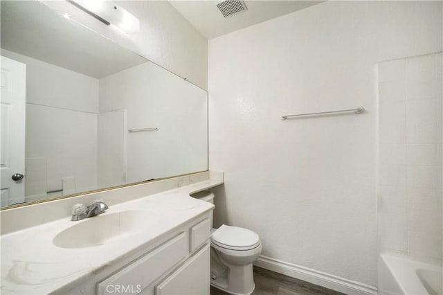 bathroom with vanity, wood finished floors, visible vents, baseboards, and toilet