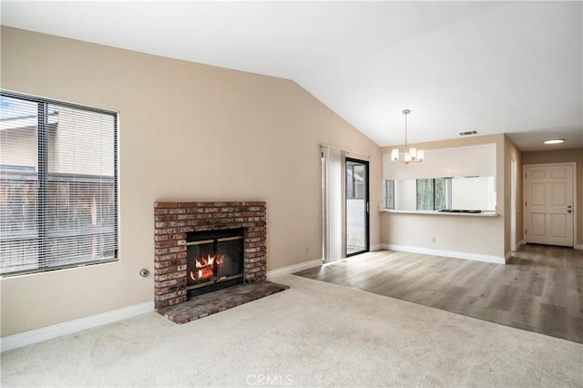 carpeted living room featuring visible vents, a brick fireplace, baseboards, vaulted ceiling, and a notable chandelier