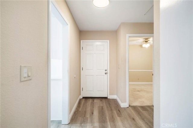 hallway featuring wood finished floors and baseboards