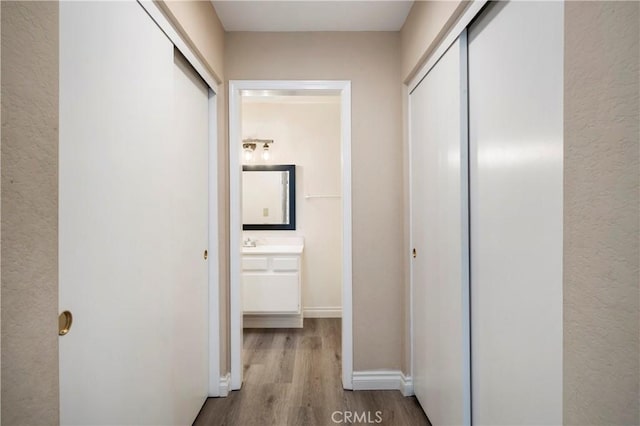 hall featuring baseboards and wood finished floors