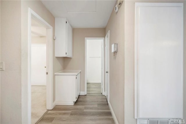 hallway with baseboards and light wood finished floors