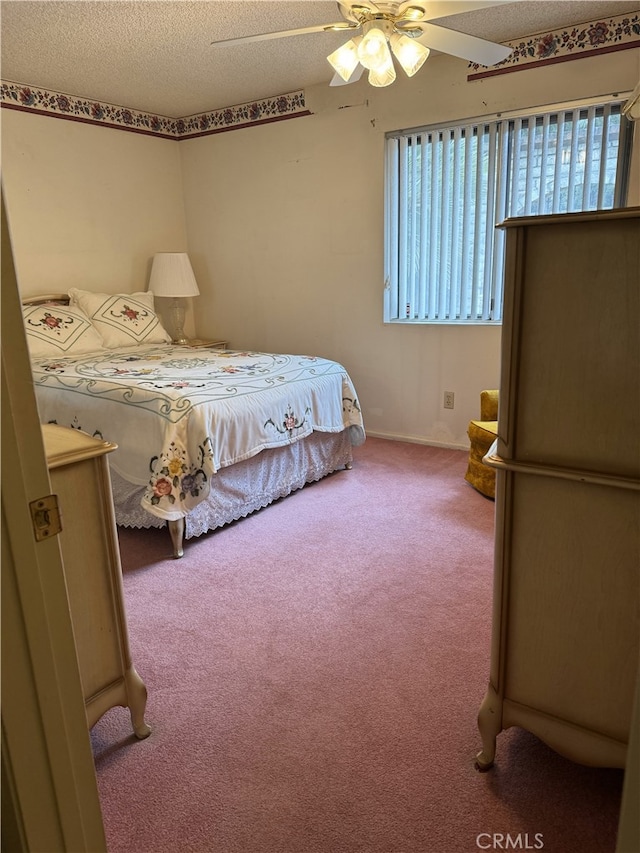 carpeted bedroom featuring multiple windows, a textured ceiling, and ceiling fan