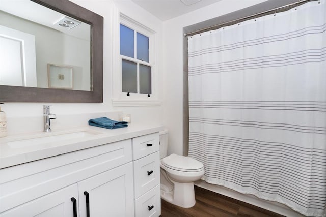 full bath featuring toilet, vanity, a shower with curtain, and wood finished floors