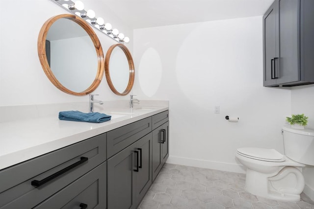 bathroom featuring tile patterned floors, toilet, vanity, and baseboards