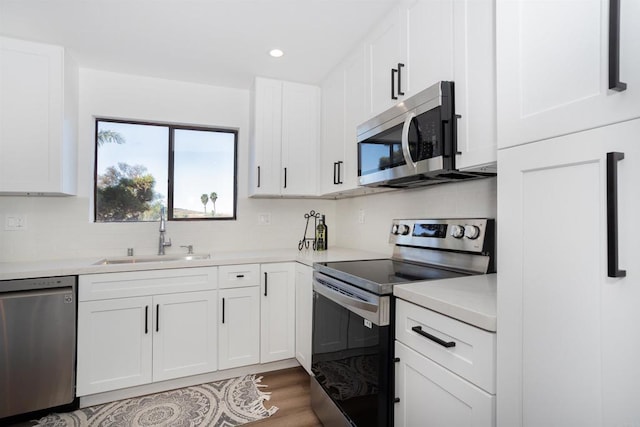 kitchen featuring a sink, light countertops, white cabinets, appliances with stainless steel finishes, and tasteful backsplash