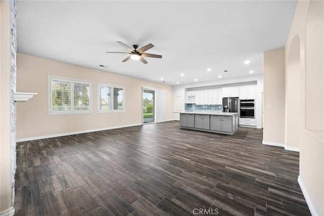 unfurnished living room featuring dark wood-style floors, recessed lighting, a ceiling fan, and baseboards