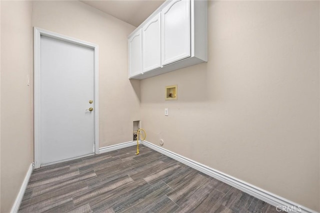 laundry area with dark wood finished floors, hookup for a washing machine, cabinet space, and baseboards