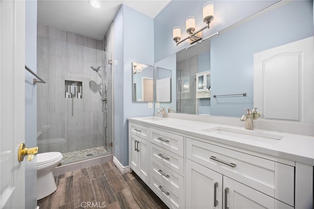 full bath with wood tiled floor, toilet, a stall shower, and a sink