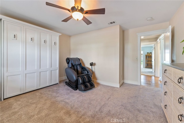 sitting room featuring visible vents, carpet, baseboards, and ceiling fan