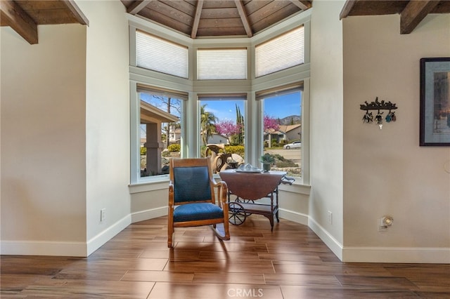 living area with beamed ceiling, wood finished floors, and a wealth of natural light