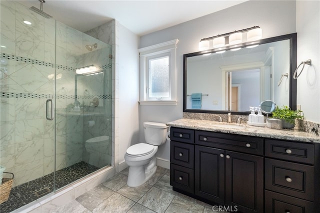 full bathroom featuring baseboards, vanity, toilet, and a shower stall