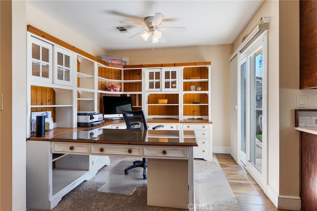 office with visible vents, baseboards, ceiling fan, and light wood-style flooring