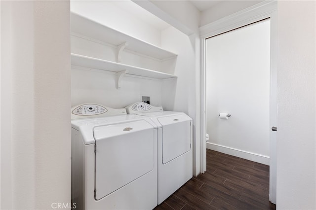 washroom with baseboards, dark wood-style floors, laundry area, and washing machine and clothes dryer