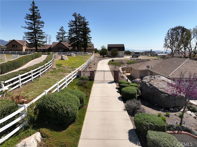 view of yard with a gate, an outdoor structure, and fence