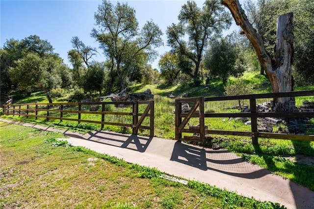 view of community featuring a yard and fence