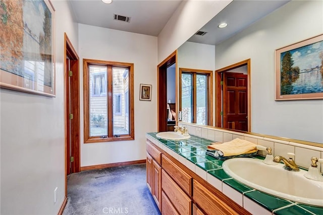 bathroom with visible vents, a sink, and a healthy amount of sunlight