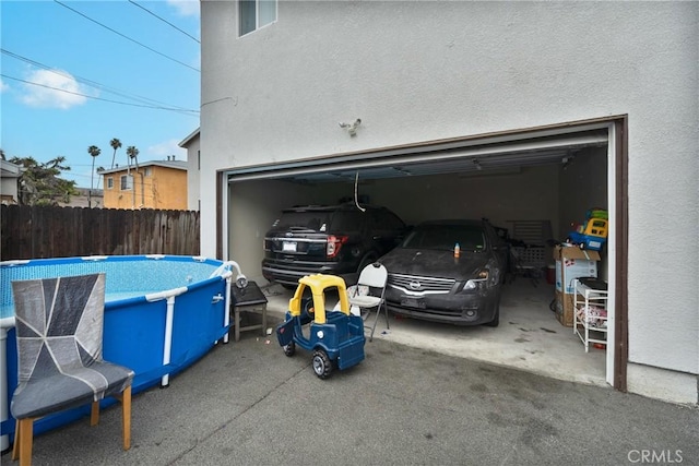 garage featuring a fenced in pool and fence