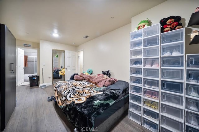 bedroom featuring visible vents, wood-type flooring, and baseboards